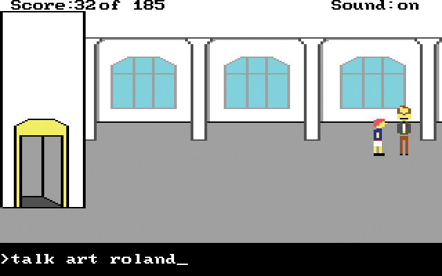 You see a screenshot from the computer game. You see a large hall, in the corner of which the protagonist is standing; he faces another person. The text ‘>talk art roland’ is visible in the input field, at the bottom of the picture.