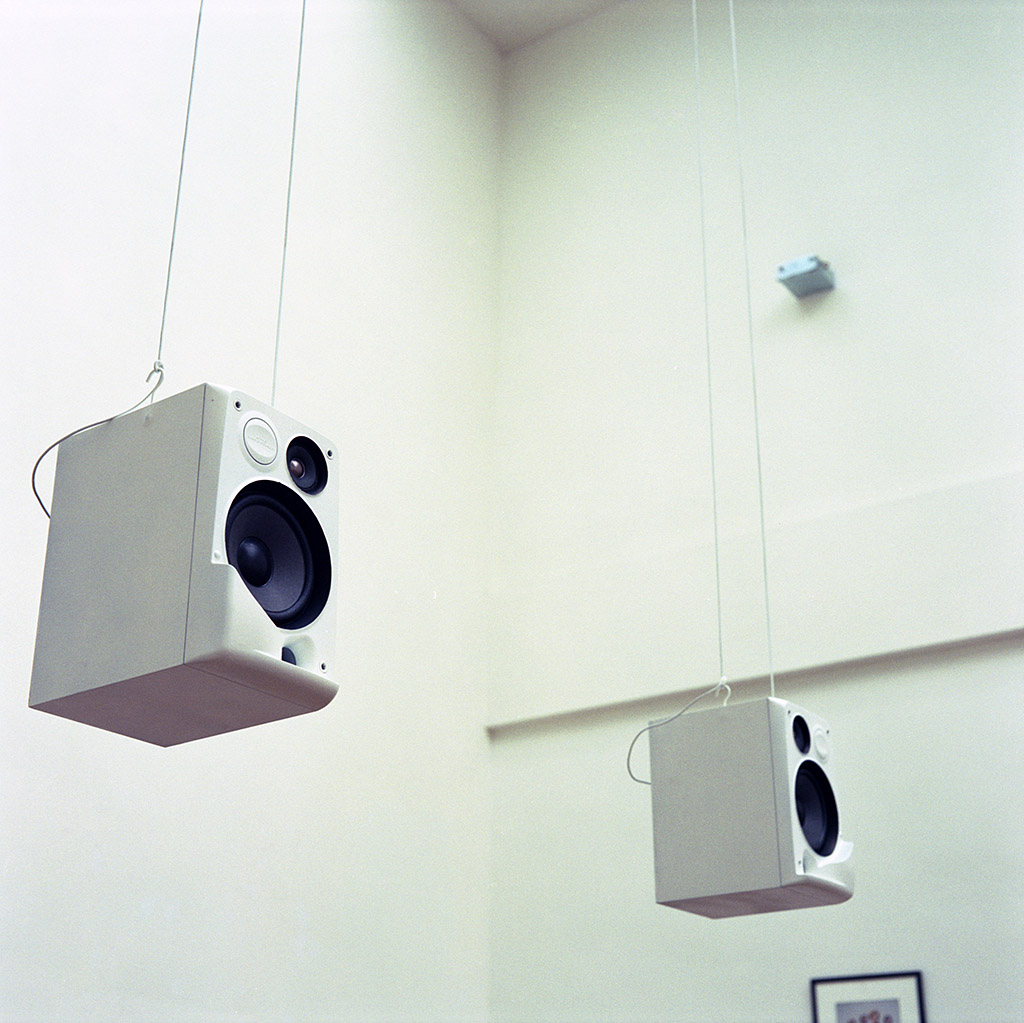 You see two white speakers hanging .